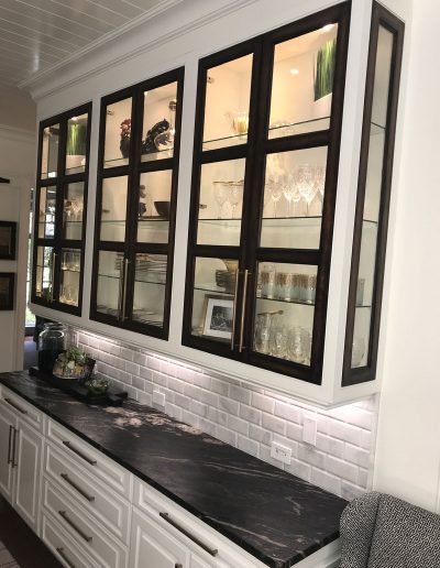 A kitchen with glass cabinets and black counter tops