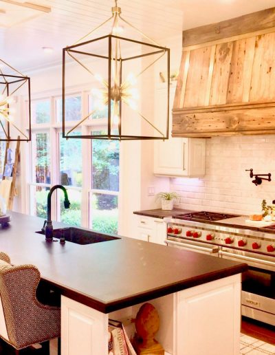 A kitchen with a stove, sink and oven.
