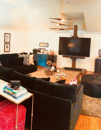 A living room with black couches and a flat screen tv.